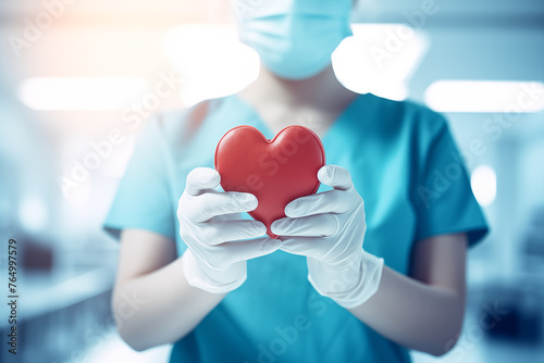 Doctor or nurse holding red heart in their hands, symbol of love and care. Healthcare and medical care concept. Cardiology and heart health. © Anastasiia