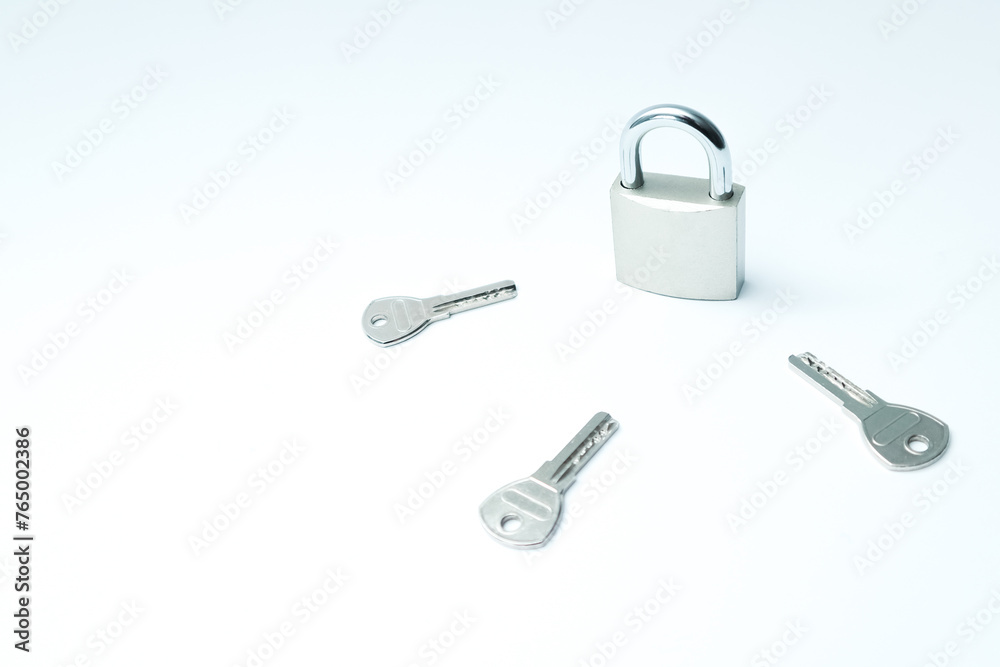 One padlock with many another keys. Many keys and one lock as concept. Different metal keys and one hinged steel padlock on a white background. One padlock with many another keys. Many keys and one lock as concept. Different metal keys and one hinged steel padlock on a white background.