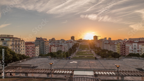 Panorama showing sunset over lawn at Alameda Dom Afonso Henriques and the Luminous Fountain aerial timelapse in Lisbon.