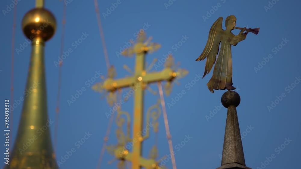 Golden dome of the Orthodox cross and the figure of an angel, and that blows. Focus translation. Golden dome of the Orthodox cross and the figure of an angel, and that blows. Focus translation.