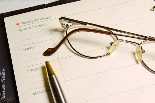 glasses lie on the blank pages of a manager’s notebook