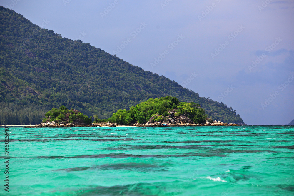 Scenic view white sand beach and crystal Andaman Sea against blue sky at Koh Lipe in Satun Province, Thailand