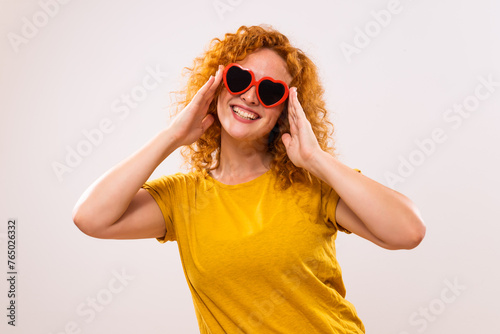 Image of happy ginger woman with red heart shaped sunglasses. 