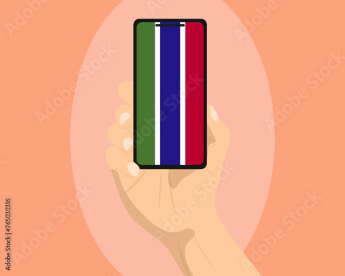 Gambia flag on mobile phone screen, holding smartphone, advertising social media or banner concept