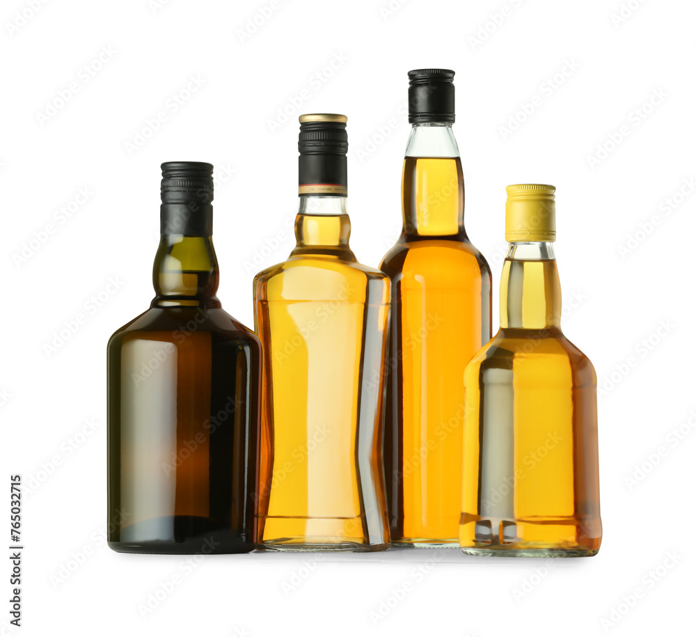 Different sorts of whiskey in glass bottles isolated on white