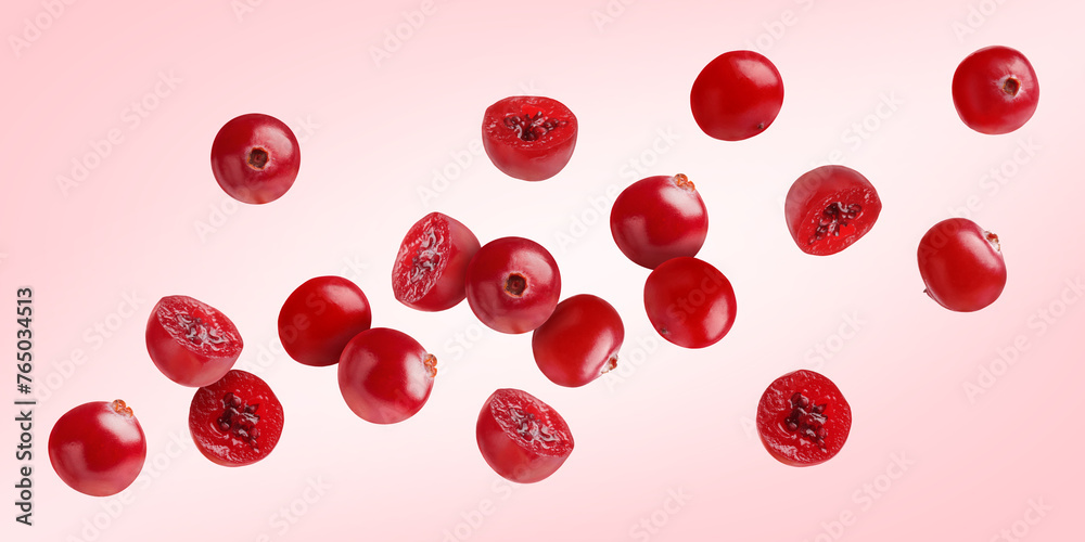Fresh red cranberries flying on pink background Fresh red cranberries flying on pink background