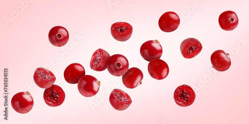 Fresh red cranberries flying on pink background