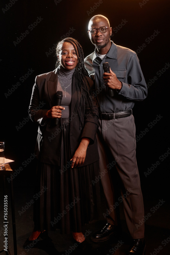 Portrait of two African American couple performing on stage together with spotlight