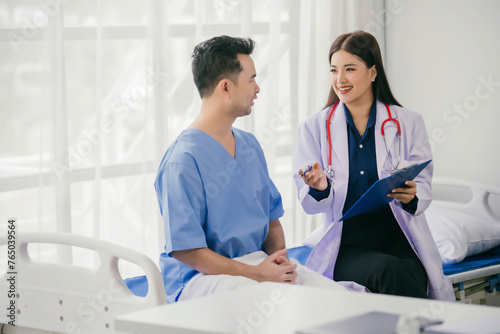 A woman in a white coat is talking to a man in a blue shirt