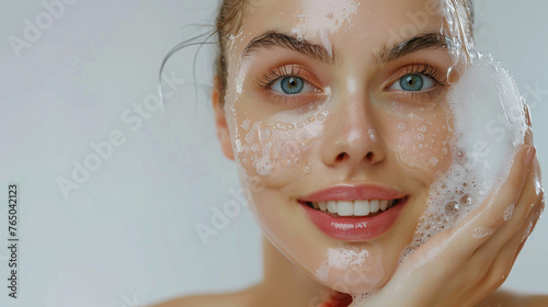 Young woman wash her face with foam. 
