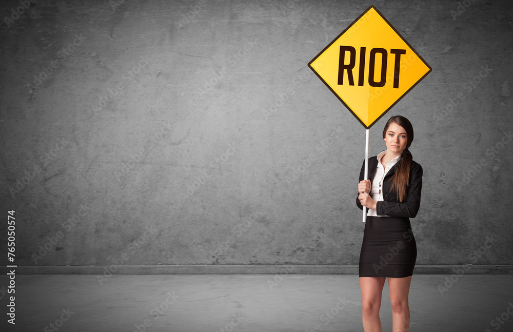 Young business person holding road sign Young business person holding road sign