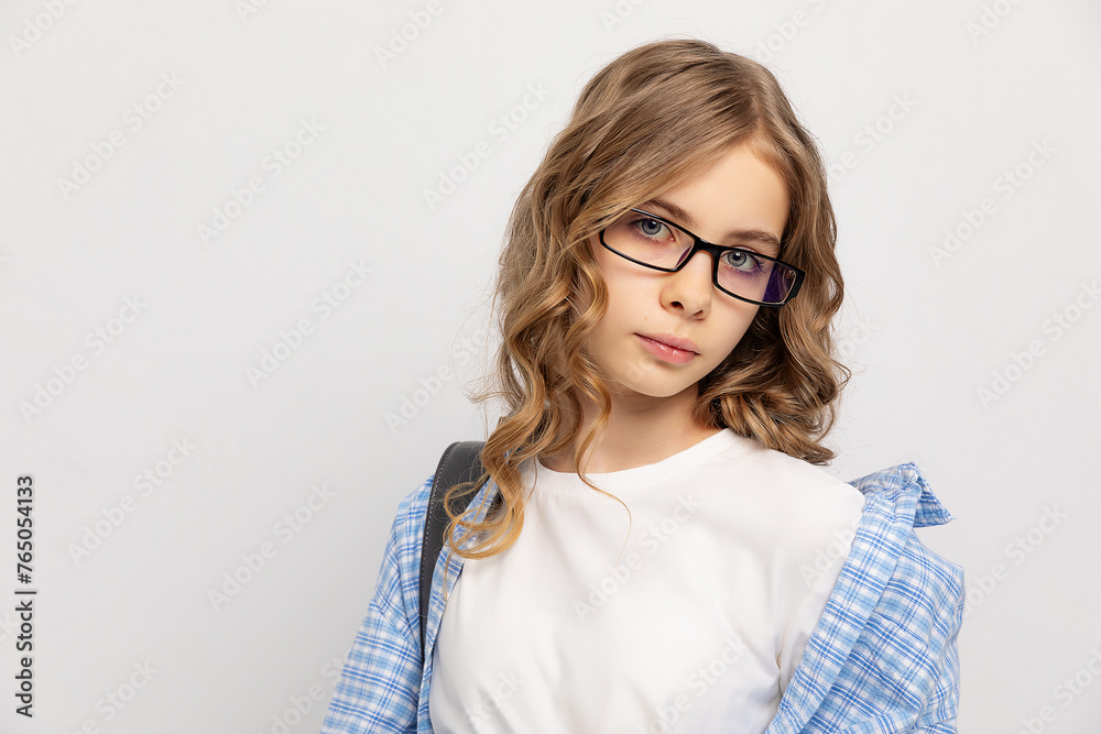Smiling blonde girl with curly hair in eyeglasses posing and looking at the camera over white background. Copy space. Education concept. Smiling blonde girl with curly hair in eyeglasses posing and looking at the camera over white background. Copy space. Education concept.