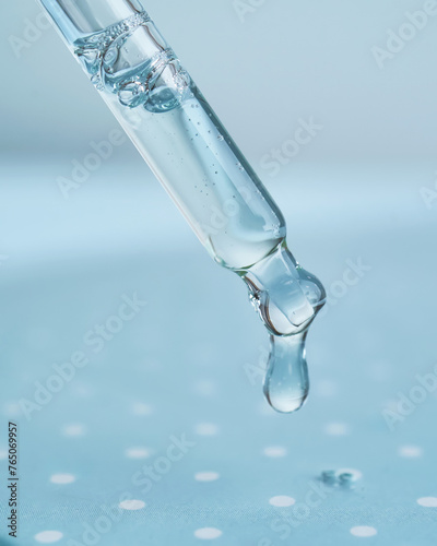 Pipette with serum on a blue background.