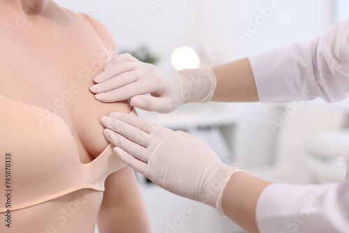 Mammologist checking woman's breast in hospital, closeup