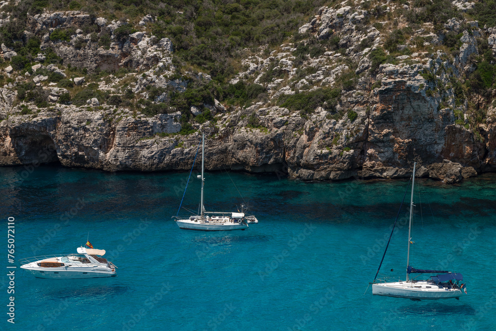 Recreational boats in the natural bay near the Spanish village of Cala en Porter on Menorca.