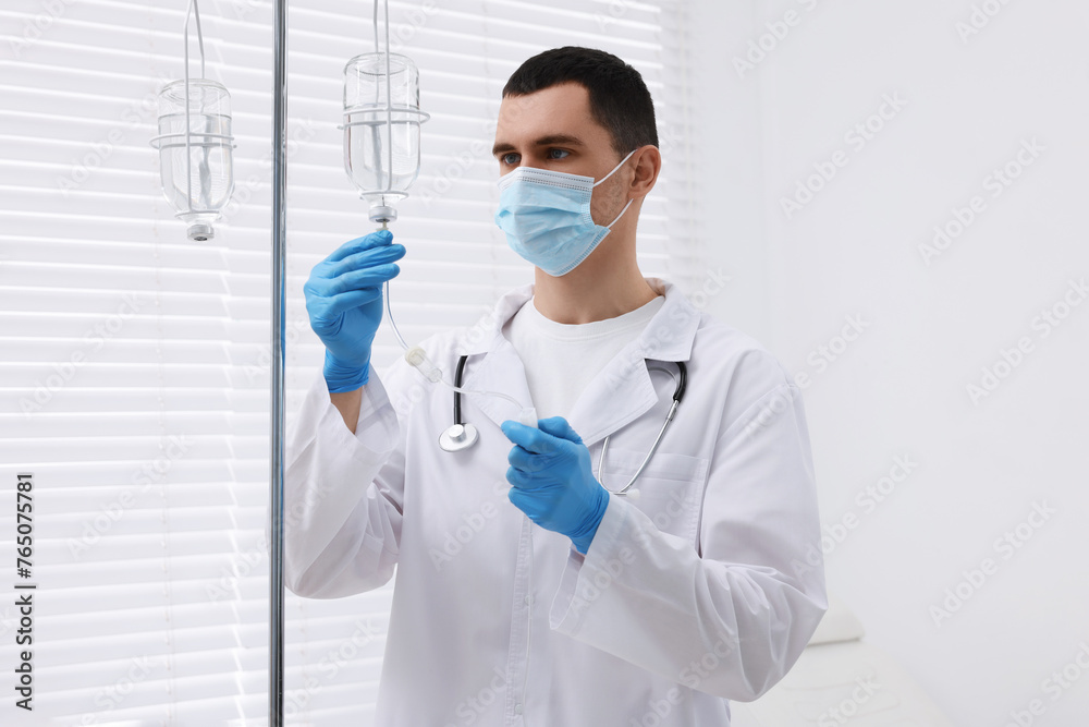 Doctor setting up IV drip in hospital Doctor setting up IV drip in hospital