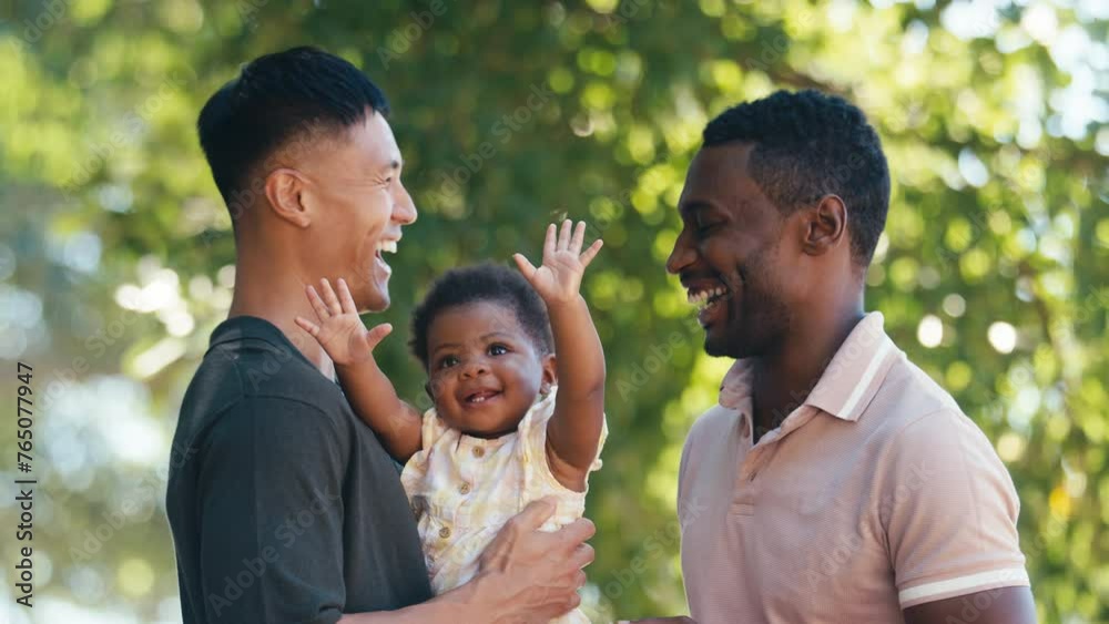 Loving same sex male couple or friends cuddling baby outdoors in garden or countryside together - shot in slow motion Stock ビデオ | Adobe Stock