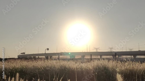 Countryside rural desert area or barren land road with moving vehicles. Bright sunset sun on sunny day summer sky. Global warming, heatwave, extreme heat and harsh climate temperature concept. photo