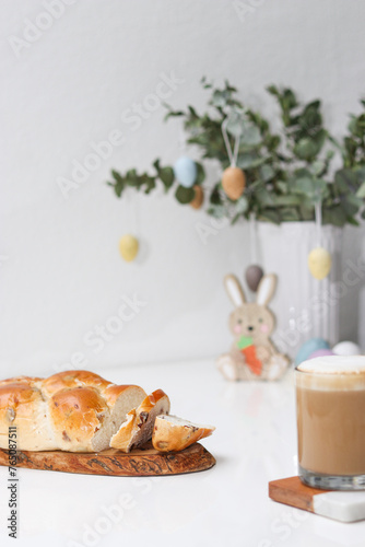 Sticker Cutted easter loaf bread on wooden plate on white table, blurry background with