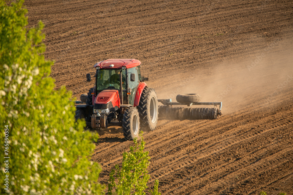 Obraz premium Farming Frontier: Tractor Tilling the Earth