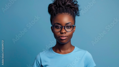 Attractive african american woman wearing blue tshirt and glasses. Isolated on blue background