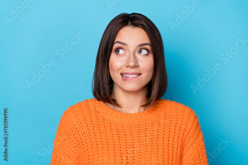 Portrait of attractive cheerful bewildered sly girl biting lip overthinking isolated over bright blue color background