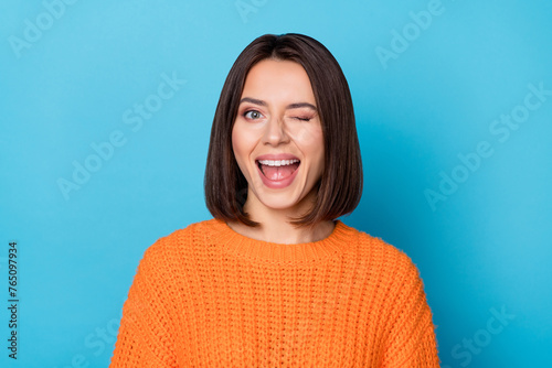 Portrait of attractive flirty cheerful girl winking good mood isolated over vibrant blue color background