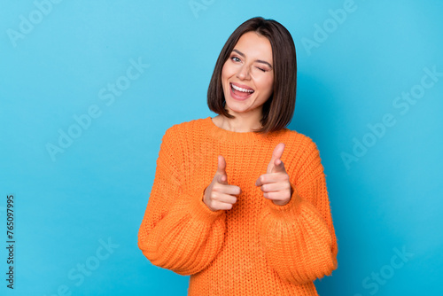 Portrait of attractive flirty funny cheerful girl winking pointing forefingers at you isolated over vibrant blue color background photo