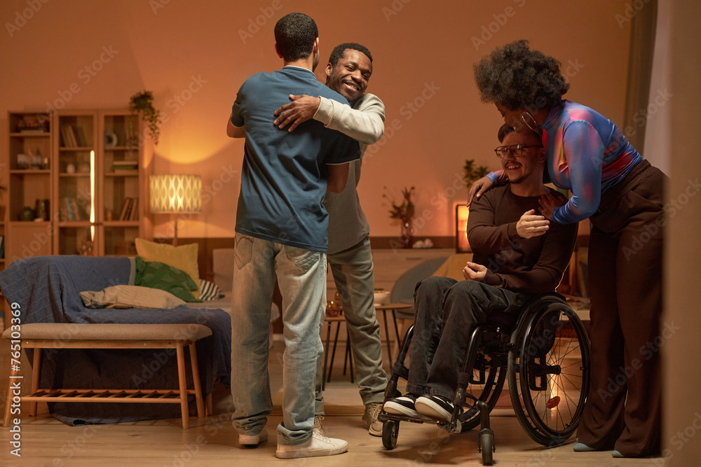 Full length shot of inclusive group of friends embracing and greeting each other for home gathering copy space