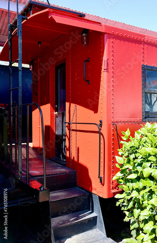 Photography bright red old fashioned caboose at the train station
