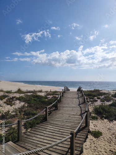 A boardwalk that leads you to the sandy shores of Portugal  where the Atlantic ocean meets the white sand.