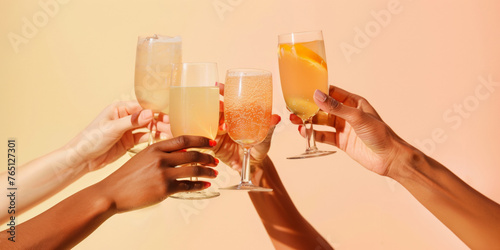 A group of hands of diverse races toasting with refreshing summer nonalcoholic drinks against a warm background