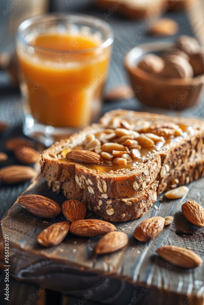 Slice of bread with almonds and glass of juice on wooden table Slice of bread with almonds and glass of juice on wooden table