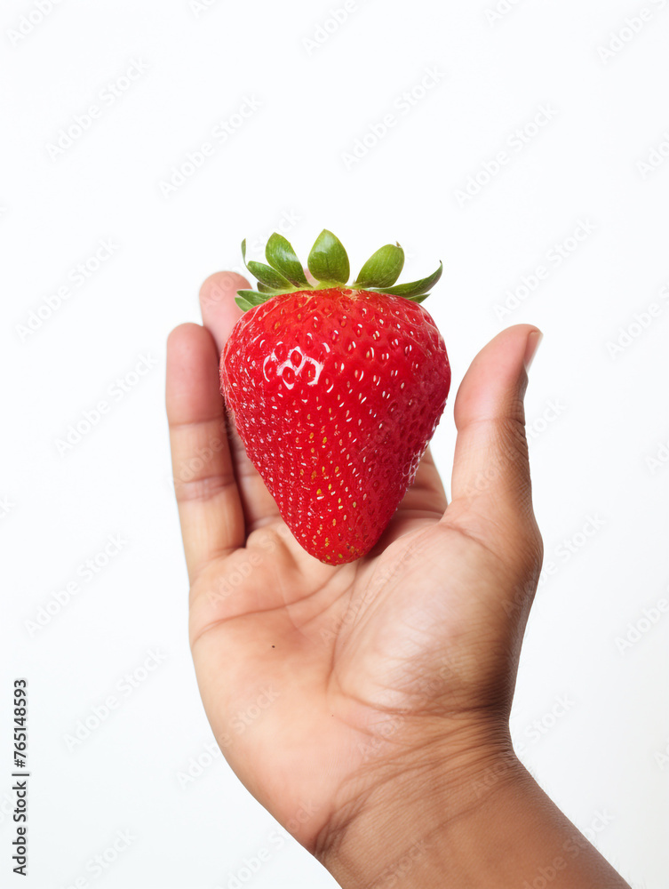 Obraz premium Holding a strawberry in his hand, against a white background сreated with Generative Ai