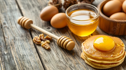 a stack of pancakes sitting on top of a wooden table next to a cup of honey and a wooden spoon.