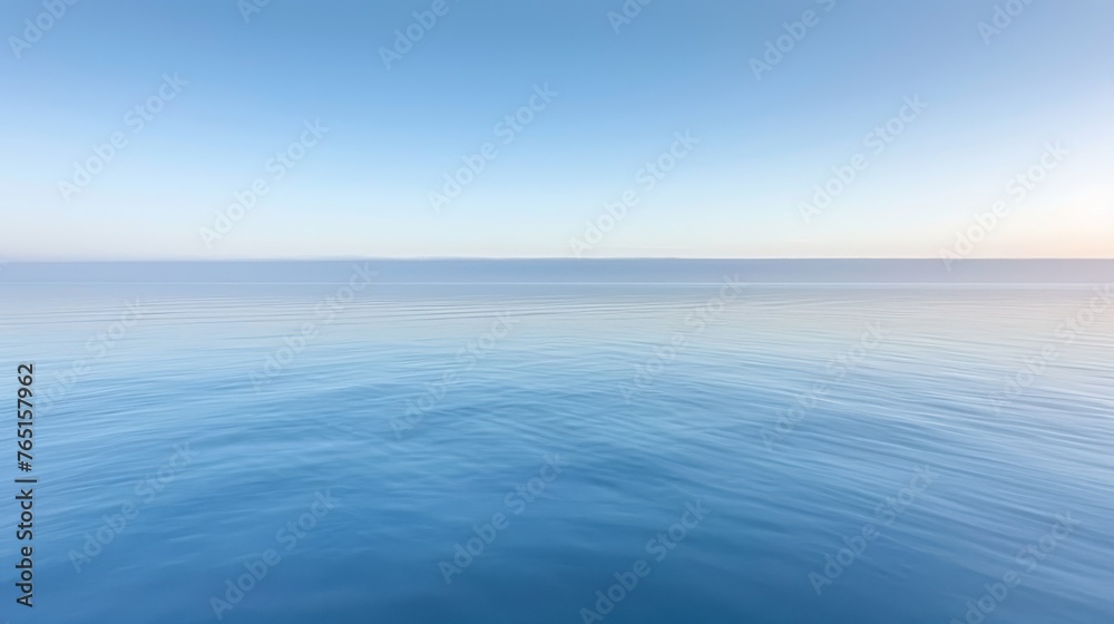 a large body of water with a bright blue sky in the background and a few small waves in the foreground.