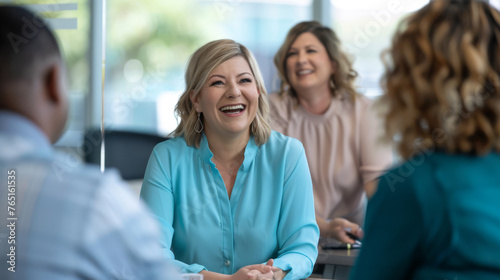A woman is laughing joyfully during a meeting with colleagues. © MP Studio