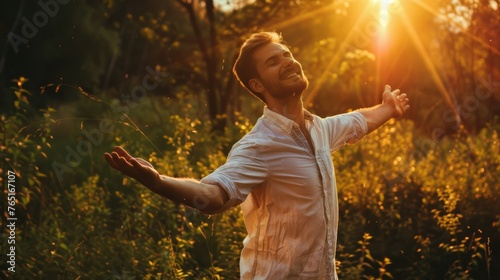 Joyful man embracing nature with open arms. Happiness and freedom concept