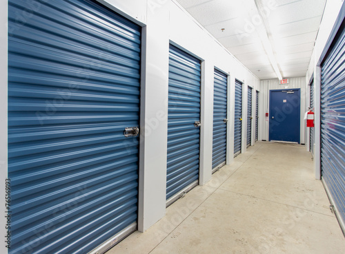 the interior of a self storage facility showing the individual storage unit metal roll up doors
