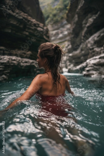 A woman in a red bikini enjoying a swim in a river. Ideal for travel and summer vacation concepts