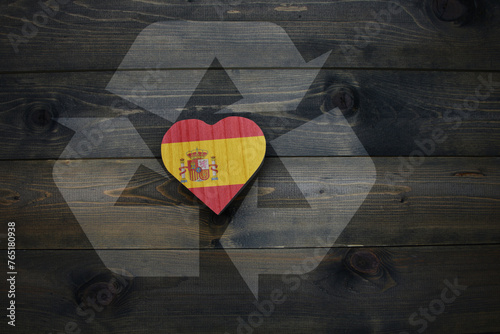 wooden heart with national flag of spain near reduce, reuse and recycle sing on the wooden background. concept photo