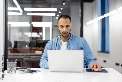 Focused professional working on laptop in modern office