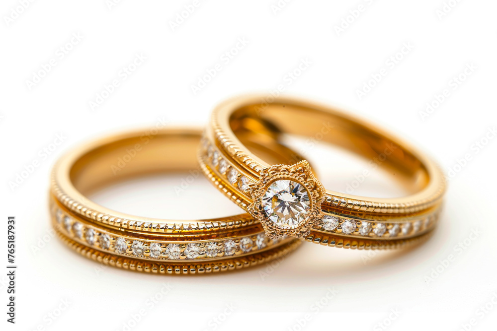 Elegant Gold Wedding Rings Adorned with Stones on a White Background