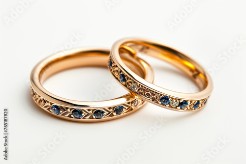 Exquisite Gold Wedding Bands Adorned with Stones on a Pure White Backdrop, Radiating Elegance