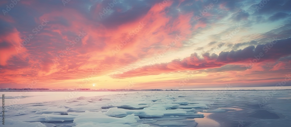 Fototapeta premium Cloudy sky over icy shore with bright winter sunset