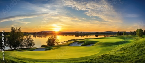 Sunset view of a golf course with a lake in the background photo