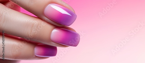 A hand displaying vibrant pink and purple ombre nail art photo