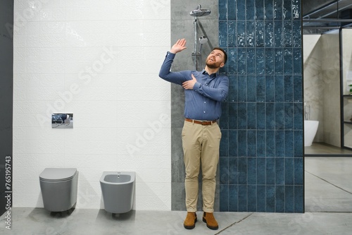 Selects a shower faucet. Man chooses a products in a sanitary ware store