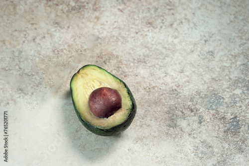 A half avocado  on a wooden background, macro photography, above vantage point photography