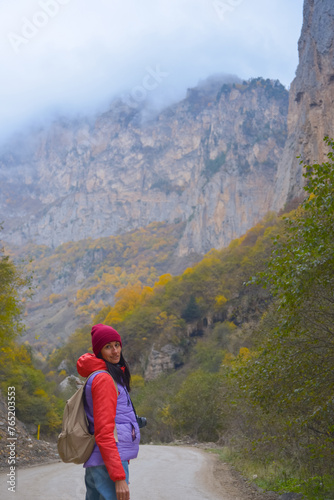 Obraz na płótnie Woman traveler on a winding road in the mountains on a foggy autumn day w salonie